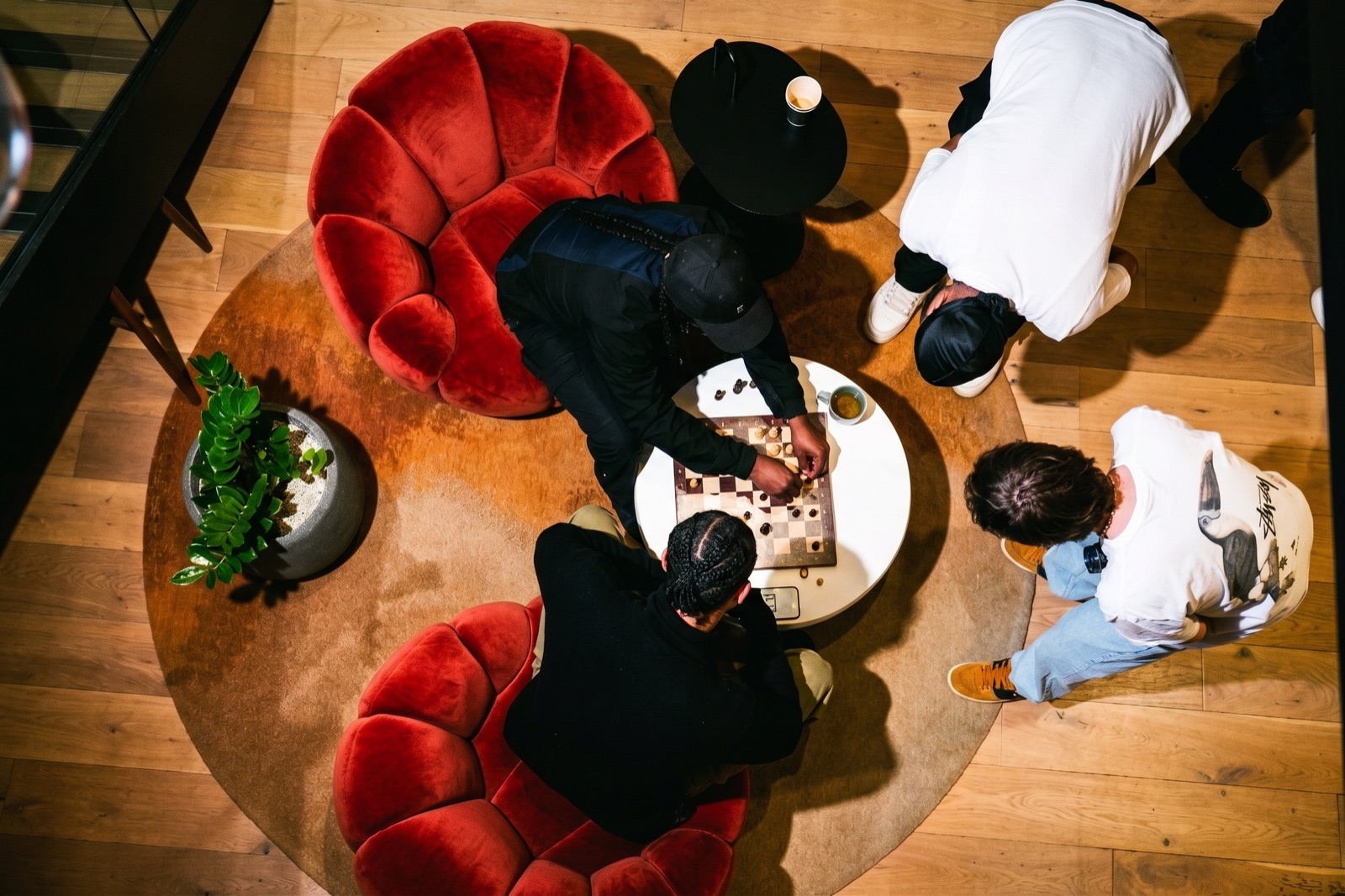 Members playing chess around a low table in the lounge