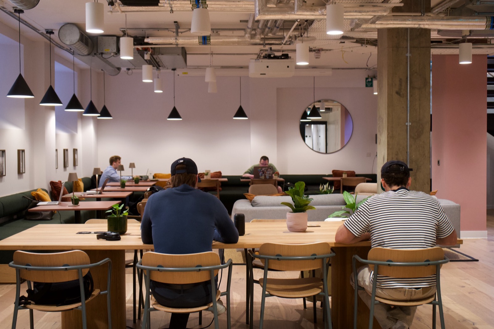 Members working at shared desks in the light-filled Juntos coworking space