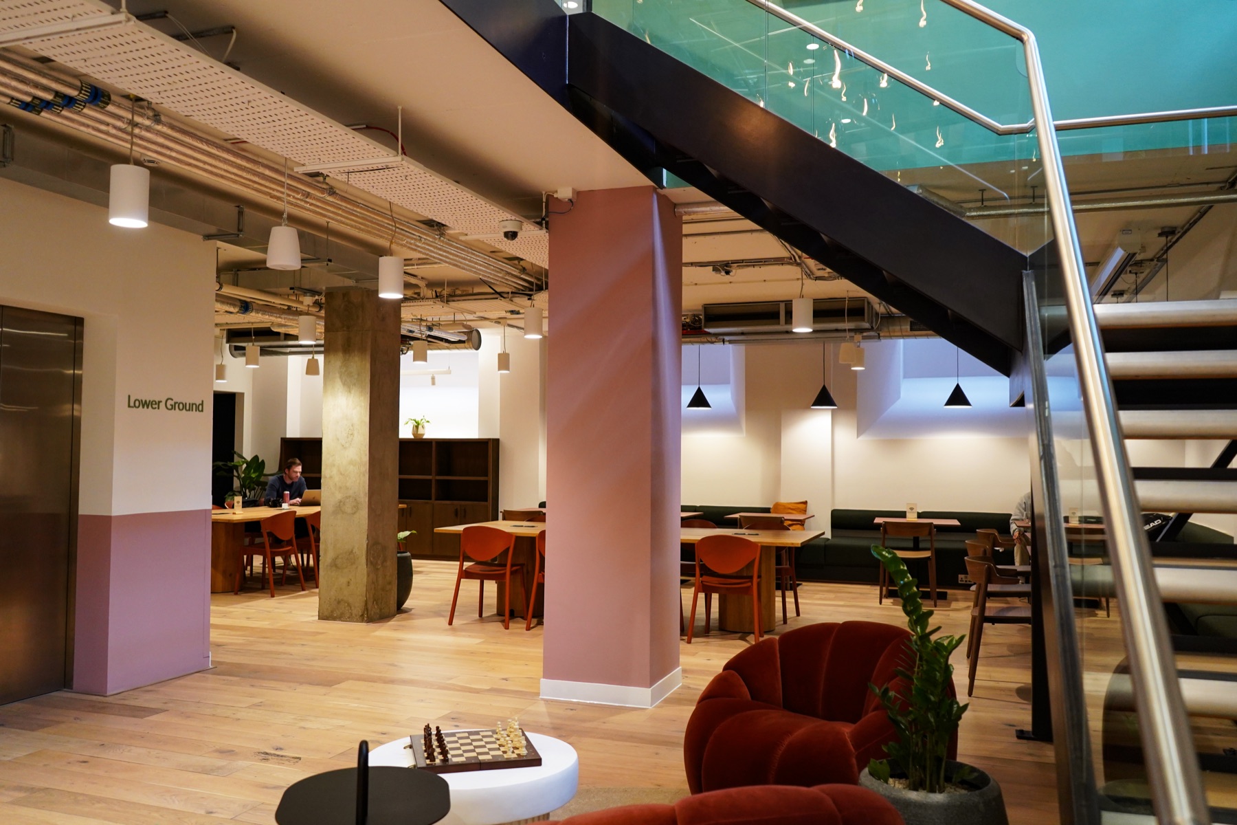 Lower-ground event space at Juntos Holborn set up for a panel talk with rows of seating