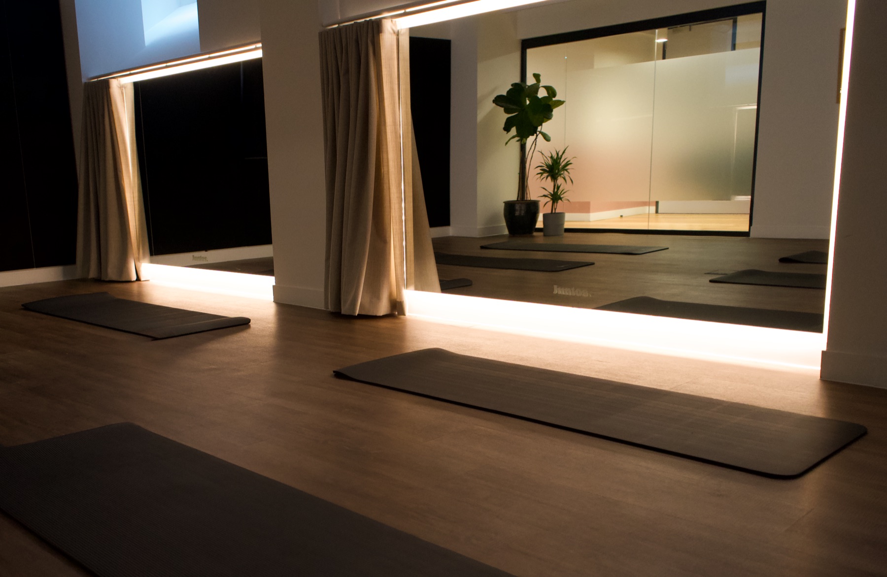 Yoga mats laid out in the softly lit Juntos wellness studio at Bedford Row