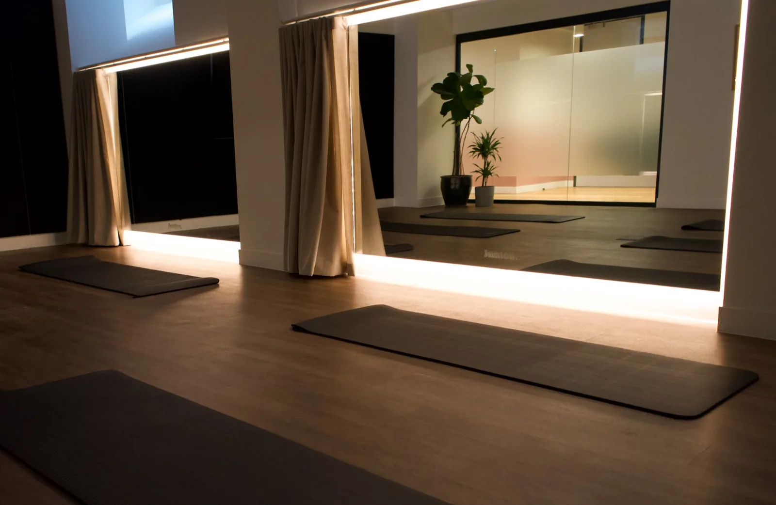 Yoga mats laid out in the softly lit Juntos wellness studio at Bedford Row